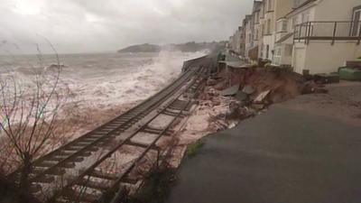 Waves crash over the suspended railway line in Dawlish