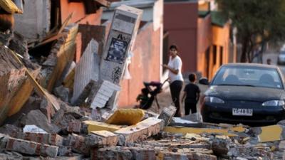 A resident looks at debris around a home after an earthquake and tsunami hit the northern port of Iquique April 2, 2014