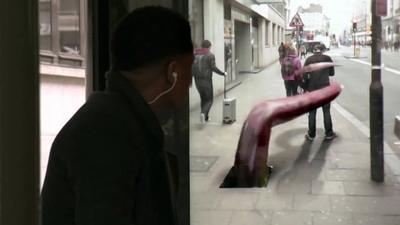 A commuter sees an optical illusion of a pedestrian being grabbed by a monster