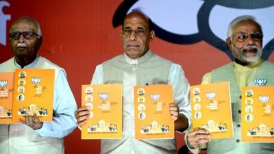 India"s Bharatiya Janata Party (BJP) Prime Ministerial candidate Narendra Modi poses with the party manifesto
