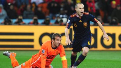 Andres Iniesta scores for Spain as Rafael van der Vaart of Netherlands looks on