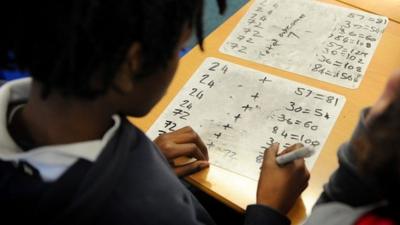 Child doing sums in a classroom