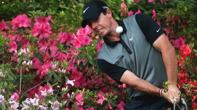 Rory McIlroy chips out of the azaleas at the 13th hole