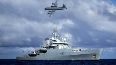 HMS Echo, as a Lockheed P-3 Orion flies overhead, in the southern Indian Ocean