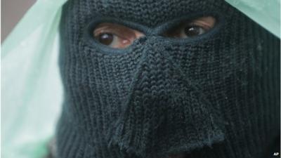 A pro-Russian gunman stands guard at a seized police station in the eastern Ukraine town of Sloviansk