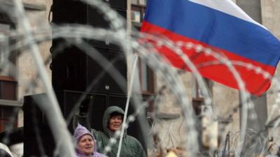 Pro-Russian activists wave a Russian flag and shout slogans