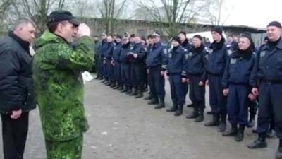 Man in military wear salutes police officers