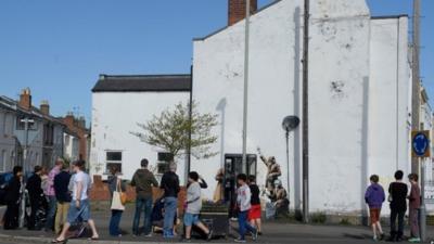 People looking at street art in Cheltenham