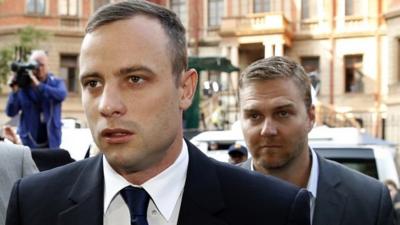 Olympic and Paralympic track star Oscar Pistorius (L) arrives ahead of his trial at North Gauteng High Court in Pretoria April 15, 2014