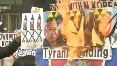 Protesters set fire to banners with portraits of North Korean leaders