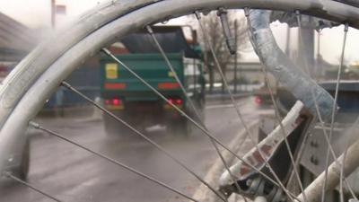 Lorry as seen through spokes of bike