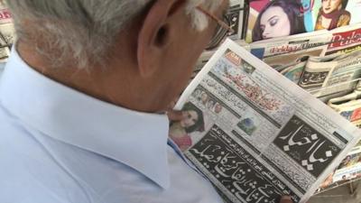 A man reads a newspaper in Pakistan