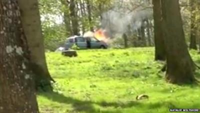 still from video showing car on fire