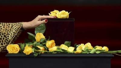 A woman touches the urn containing the ashes of Gabriel Garcia Marquez