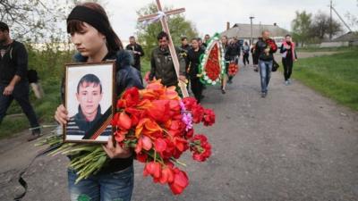 A funeral procession walks with the remains of 24-year-old Sasha, a pro-Russian activist, as they are carried from his familys home in the small village of Aleksandrovka to the village graveyard on April 22, 2014 near Sloviansk Ukraine