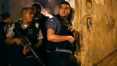 Rio de Janeiro's state military policemen stand in position during a violent protest in a favela next to Copacabana, Rio de Janeiro on April 22, 2014