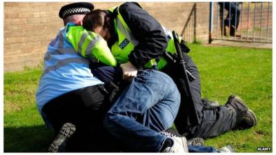 Police restrain a man