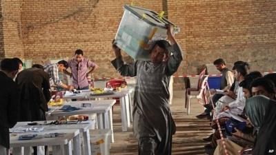 A worker for the Afghan election commission office unloads ballot boxes in Herat Province (20 April 2014)