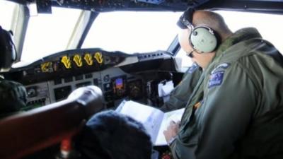 A pilot checks a map during the search for the missing Malaysian airliner