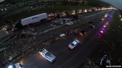 A still from aerial drone footage shows emergency vehicles and debris on a highway south of Mayflower, Arkansas