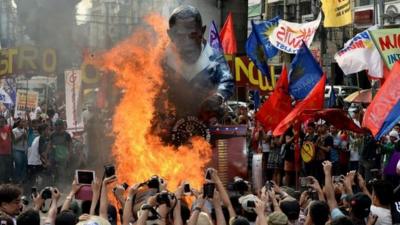 Protesters burn a US President Barack Obama effigy during an anti-US protest in Manila