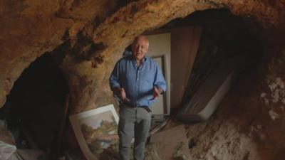 The BBC's Jeremy Bowen inside a cave being used as a home on the West Bank