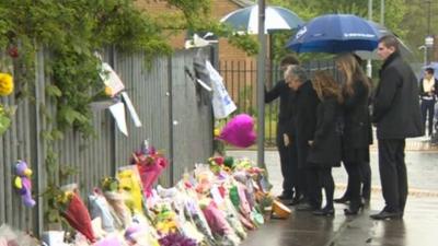 Ann Maguire's family inspect floral tributes