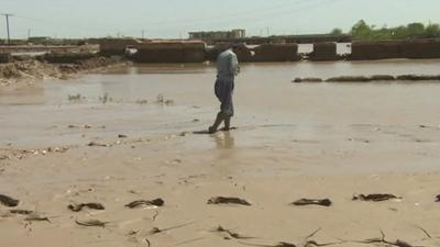 Afghan man walking through the mud after the floods in north of the country