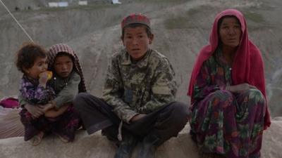 Afghan villagers look on at the scene in Argo district of Badakhshan province on May 3, 2014 after a massive landslide May 2 buried a village