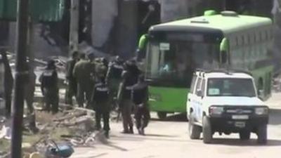 A bus starts to evacuate people from Homs