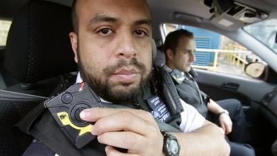 Constable Yasa Amerat (left) and Constable Craig Pearson pictured in their police car wearing body-worn video (BWV) cameras