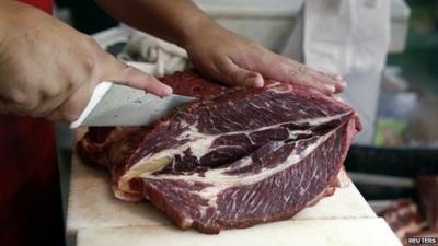 A man chopping a cut of beef