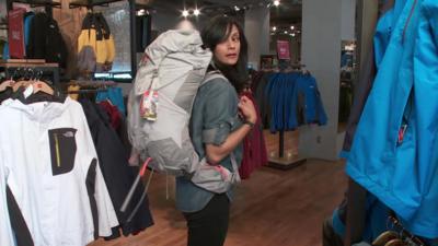 Sumi Das wears a backpack in a shop