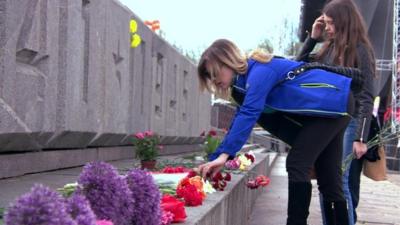 Girl laying flowers at memorial