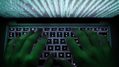 A man typing on a computer keyboard