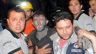 Men help a rescued miner after Turkey blast