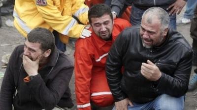 Relatives of miners who were killed or injured in a mine explosion react as rescuers work in Soma