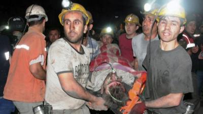 Men help a rescued miner after Turkey blast