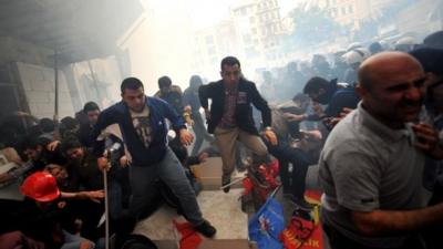 Protestors run away from tear gas during a protest on Istiklal avenue in Istanbul on May 14, 2014.