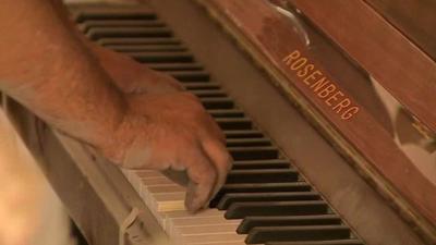 Man plays dusty piano inside Homs