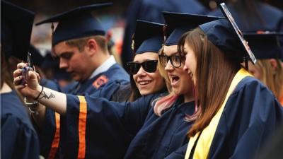 University students take a 'selfie' at graduation ceremonies