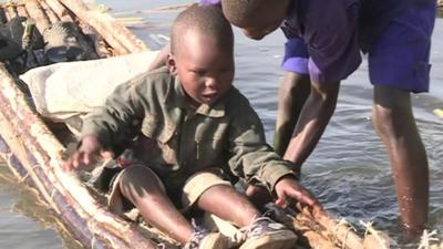 Child gets to dry land in flooded Nakuru National Park