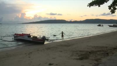 Boy and boat at a beach