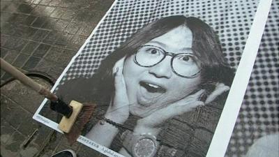 A selfie of a woman pasted on to a pavement