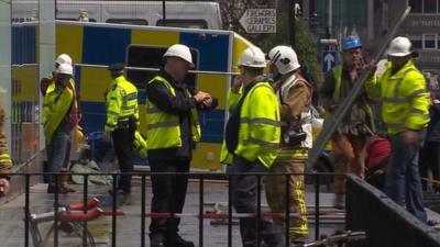 Firefighters begin to remove items from the Charles Rennie Mackintosh building