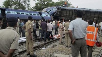 Indian officials and rescuers gather around the wreckage after the Gorakhpur Express passenger train slammed into a parked freight train Chureb, near Basti, Uttar Pradesh state