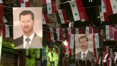 Pictures of Bashar al-Assad hanging amongst Syrian flags