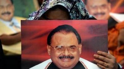 Supporters of Pakistan's MQM party hold photographs of their party leader Altaf Hussain