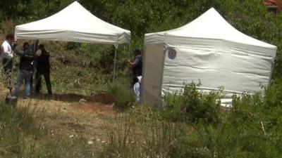 Police officers search an area of scrubland in the Madeleine McCann case