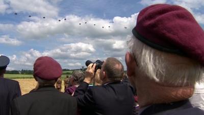 Veterans watch the parachute drop as part of the D-Day ceremony